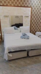 two twin beds in a room with a mirror at Hospedaria Restaurante Xeque Mate in Luanda