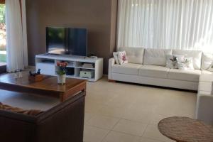 un soggiorno con un divano e una TV di Casa de Luxo Costa do Sauipe a Mata de Sao Joao