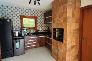 una cucina con muro di mattoni e frigorifero di Casa de Luxo Costa do Sauipe a Mata de Sao Joao