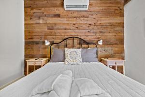 1 dormitorio con 1 cama con pared de madera en The Brick House-Walk DT or U of A- 3 Suites, en Fayetteville