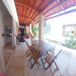 Casa Boa Venttura Piscina,guajiru,flecheiras e mundaú في ترايري: طاولة وكراسي خشبية على الفناء