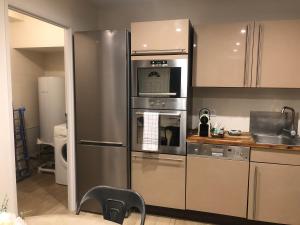 a kitchen with a stainless steel refrigerator and microwave at Appartement T2 spacieux et équipé in Mions