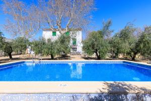 a swimming pool in front of a house with trees at Mas Xanxo in Riudoms