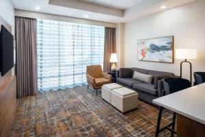 a living room with a couch and a chair at Embassy Suites Huntsville in Huntsville