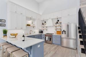 a kitchen with white cabinets and a blue island at The Brownstone-1 Block to Downtown Bentonville in Bentonville