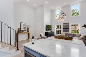 a white kitchen and living room with a couch at The Brownstone-1 Block to Downtown Bentonville in Bentonville
