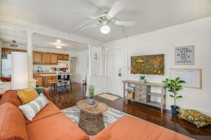 a living room with an orange couch and a kitchen at The Clementine - Monthly Rental - Walk Everywhere in Fayetteville