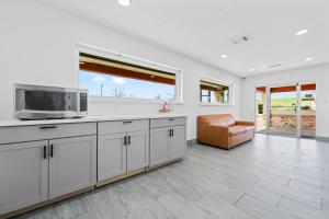 een keuken met witte kasten, een magnetron en een stoel bij Econo Lodge Inn & Suites Sealy in Sealy