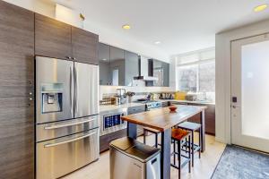 a kitchen with stainless steel appliances and a wooden table at Urban Oasis in Seattle