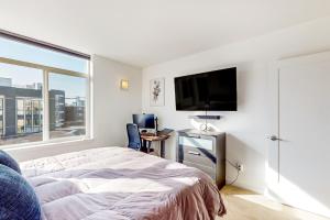 um quarto com uma cama e uma televisão de ecrã plano em Urban Oasis em Seattle