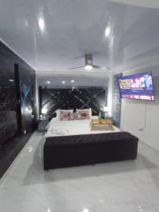 a bedroom with a large bed and a flat screen tv at Hermosa habitación 202!! in Guatapé