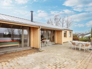 Cette maison dispose d'une terrasse avec une table et des chaises. dans l'établissement Holiday home Rønde, à Rønde