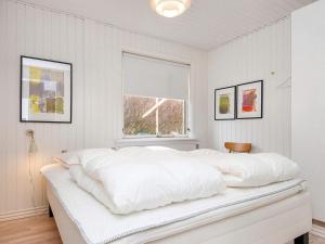 un letto bianco in una camera bianca con finestra di Holiday home Rønde a Rønde