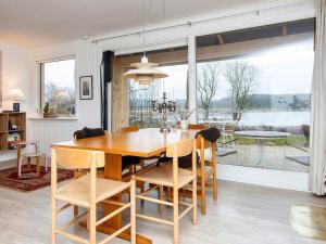 - une salle à manger avec une table et des chaises en bois dans l'établissement Holiday home Rønde, à Rønde