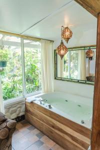 a bath tub in a room with a window at Spa Hosteria Miramelindo in Baños