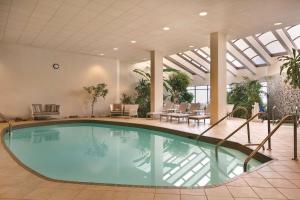 a large swimming pool in a hotel lobby with a table and chairs at Embassy Suites by Hilton Richmond in Richmond