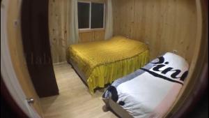 a small room with two beds and a window at cabañas arrayanes in Puyehue