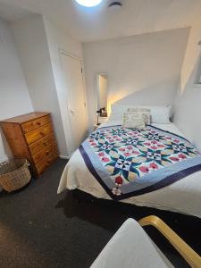 - une chambre avec un lit et une commode en bois dans l'établissement The Bunker Torbay, à Auckland