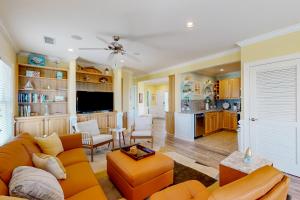 a living room with an orange couch and a kitchen at Lucky Break in Hatteras