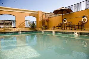 a large swimming pool with chairs and an umbrella at Hotel Zessa Orange County Airport, a DoubleTree by Hilton in Santa Ana