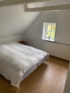 a white bedroom with a bed and a window at Søbugten in Nykøbing Mors