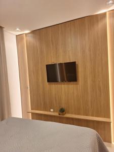 um quarto com uma televisão de ecrã plano na parede em Apto na Borges de Medeiros. em Gramado