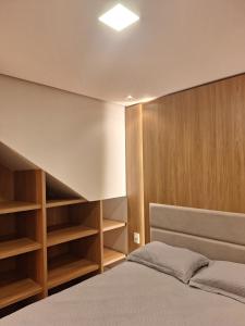 1 dormitorio con estanterías de madera y 1 cama en Apto na Borges de Medeiros., en Gramado