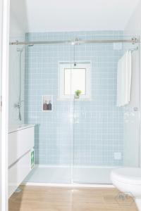 bagno con doccia e piastrelle blu di MC Suites Burgau with amazing front sea view a Burgau