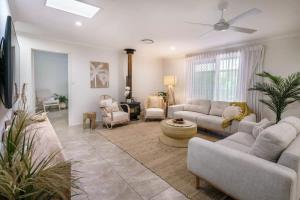 a living room with couches and chairs and a fan at Coolum Family Hideaway - Private Pool & Sauna in Coolum Beach