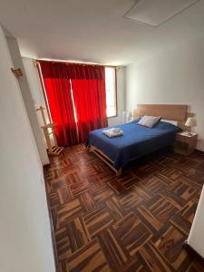 - une chambre avec un lit et un rideau rouge dans l'établissement Harmony Inn Miraflores, à Lima