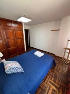a bedroom with a blue bed and a wooden door at Harmony Inn Miraflores in Lima