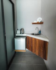 a small kitchen with a sink and a dishwasher at Pondok Beach Shack in Tioman Island