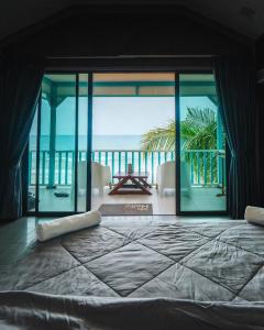 Pondok Beach Shack في جزيرة تيومان: غرفة نوم بسرير كبير مطلة على المحيط