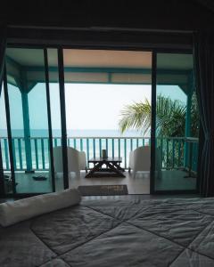 a bedroom with a bed and a view of the ocean at Pondok Beach Shack in Tioman Island