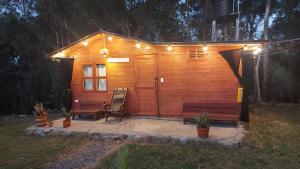 Cabaña de madera con 2 bancos y luces. en Mundo Nuevo Cabañas, en Ráquira