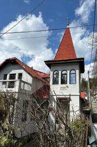 un edificio con tetto rosso e torre di Vila Agata a Sinaia