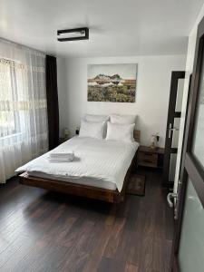 una camera da letto con un grande letto con lenzuola bianche di Vila Agata a Sinaia