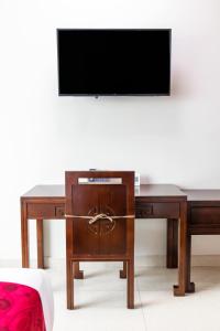 una scrivania in legno con una televisione sopra di Golden Bay Belize Hotel a Belize City