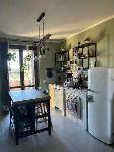 een keuken met een tafel, een fornuis en een koelkast bij Incanto e relax nel verde in Città della Pieve