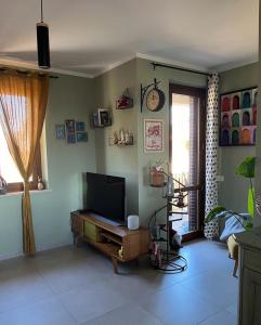 een woonkamer met een flatscreen-tv aan de muur bij Incanto e relax nel verde in Città della Pieve