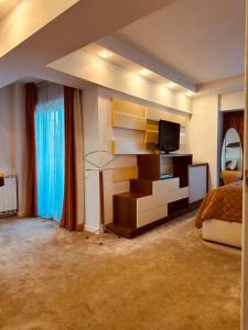 Un dormitorio con una cama y un televisor en un estante. en Top Home Residence Unirii Center, en Bucarest