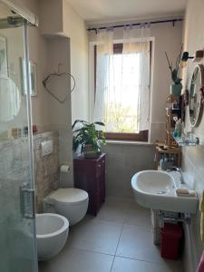 een badkamer met 2 wastafels, een toilet en een douche bij Incanto e relax nel verde in Città della Pieve