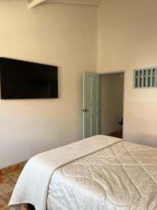 a bedroom with a bed and a flat screen tv at Encanto Azul en Villa in Villa de Leyva