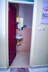 een badkamer met een wastafel en een rode deur bij The Sunset Home's in Mombasa