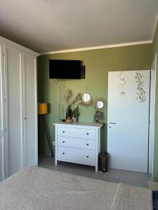een slaapkamer met een wit dressoir en een tv aan de muur bij Incanto e relax nel verde in Città della Pieve