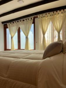 een slaapkamer met een groot bed en ramen bij Apartamento en Villa de Leyva in Villa de Leyva