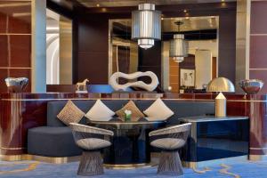 a lobby with a couch and a table and chairs at Waldorf Astoria Lusail, Doha in Doha