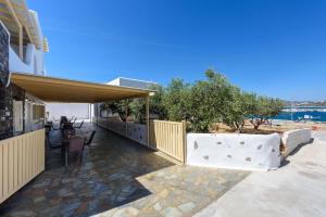 a patio of a house with a table and chairs at Sea Breeze Studios Paros II in Aliki