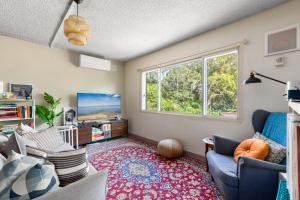 a living room with a couch and a window at Cosy Sydenham 1-Bed by Inner-West's Attractions in Sydney