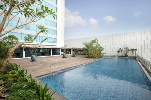 a swimming pool in front of a building at DoubleTree by Hilton Jakarta Kemayoran in Jakarta